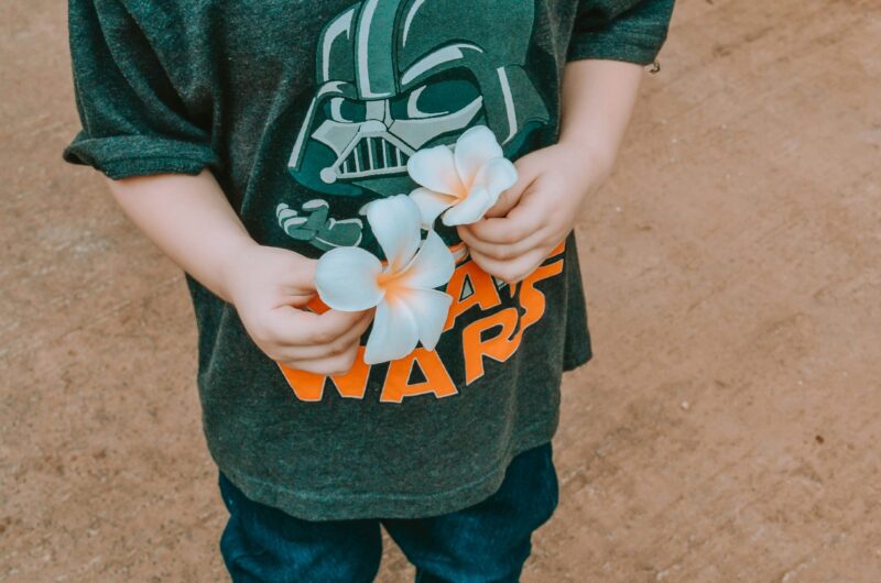 Child holding plumeria flowers